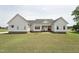 Rear exterior featuring light siding, neutral trim, well-maintained landscaping and a spacious lawn at 105 Bagley Ln, Dunn, NC 28334