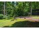 A grassy backyard with pergola, patio, and storage shed at 106 Redbud, Pittsboro, NC 27312