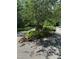 Stone-lined driveway entrance marked with a 'Redbud' sign, surrounded by lush greenery at 106 Redbud, Pittsboro, NC 27312