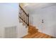 Bright entryway featuring hardwood floors, a staircase with wooden banister, and a white front door at 106 Redbud, Pittsboro, NC 27312
