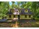 Charming two-story home with dormer windows and a welcoming deck, surrounded by beautiful mature trees at 106 Redbud, Pittsboro, NC 27312