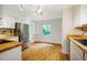 Well-lit kitchen featuring white cabinets, stainless steel appliances, and hardwood floors at 106 Redbud, Pittsboro, NC 27312