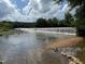 Picturesque view of a wide, cascading waterfall surrounded by trees on a sunny day at 106 Redbud, Pittsboro, NC 27312