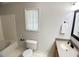 Well-lit bathroom featuring a toilet, tub, sink with cabinet, and decorated window at 109 Elmview Dr, Cary, NC 27519