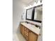 Bright bathroom showcasing a double sink vanity with wood cabinets and large framed mirrors at 109 Elmview Dr, Cary, NC 27519