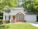 Charming two-story home with a red brick facade, complemented by a lush green lawn and an attached two-car garage at 109 Elmview Dr, Cary, NC 27519