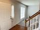 Inviting foyer featuring hardwood floors, a staircase, and a front door, creating a warm and welcoming entry to the home at 109 Elmview Dr, Cary, NC 27519