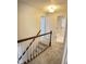 Carpeted hallway with stairwell leading upstairs with two doors on the left and bathroom at 109 Elmview Dr, Cary, NC 27519