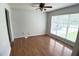Bright living room with hardwood floors, a ceiling fan, and a large window, offering a comfortable and airy space at 109 Elmview Dr, Cary, NC 27519
