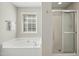 Well-lit bathroom showcases garden tub and separate glass shower at 109 Faldo Cv, Raleigh, NC 27603