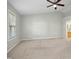 Light-filled bedroom with neutral carpet, vaulted ceiling, fan and a view to an ensuite bathroom at 109 Faldo Cv, Raleigh, NC 27603