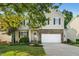 Two-story home with stone accents, a two-car garage, neutral siding, and a well-manicured lawn at 109 Faldo Cv, Raleigh, NC 27603