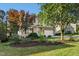 Landscaped front yard with mature trees leading to a charming two-story home with stone accents at 109 Faldo Cv, Raleigh, NC 27603