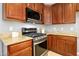 Close-up of a stainless steel gas range and microwave against granite countertops and wooden cabinets at 109 Faldo Cv, Raleigh, NC 27603