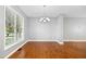 Bright living room with hardwood floors, large windows, and neutral gray walls at 109 Faldo Cv, Raleigh, NC 27603