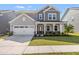 Charming two-story home with a well-manicured lawn, white garage door, and covered front porch at 1165 Sun Spgs Rd, Wake Forest, NC 27587