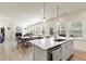 Open-concept kitchen with a large island, modern lighting, and seamlessly connected dining area at 1165 Sun Spgs Rd, Wake Forest, NC 27587