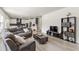 Open-concept living room flowing into the kitchen, featuring gray couches, stairs, and light hardwood floors at 1165 Sun Spgs Rd, Wake Forest, NC 27587