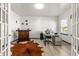 A well-lit office space with French doors, a modern desk setup, and a decorative rug at 1165 Sun Spgs Rd, Wake Forest, NC 27587