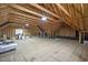 Unfinished attic with wood beams, flooring, and storage space at 117 Synandra Ln, Holly Springs, NC 27540