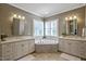 Bright Primary bathroom with dual vanities, corner tub, and plenty of counter space at 117 Synandra Ln, Holly Springs, NC 27540