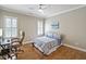 Neutral bedroom boasts hardwood floors, natural light, and a ceiling fan at 117 Synandra Ln, Holly Springs, NC 27540