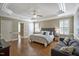 Spacious bedroom with hardwood floors, tray ceiling, and a cozy sitting area at 117 Synandra Ln, Holly Springs, NC 27540