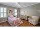 Comfortable bedroom with wood floors, a ceiling fan, and plantation shutters at 117 Synandra Ln, Holly Springs, NC 27540