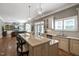 Open-concept kitchen featuring a granite island with barstool seating, stainless appliances, and hardwood floors at 117 Synandra Ln, Holly Springs, NC 27540