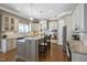 Spacious kitchen featuring bar stool seating, stainless appliances, and hardwood floors at 117 Synandra Ln, Holly Springs, NC 27540