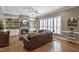 Living room featuring a stone fireplace, built-in shelving, and hardwood floors with lots of natural light at 117 Synandra Ln, Holly Springs, NC 27540