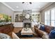 Cozy living room featuring a stone fireplace, built-in shelving, and hardwood floors at 117 Synandra Ln, Holly Springs, NC 27540