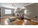 Cozy bonus room with a leather sofa, ottoman, hardwood floors, and vaulted ceilings at 117 Synandra Ln, Holly Springs, NC 27540