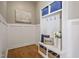 Well-organized mudroom with storage cubbies, hooks, bench, and decorative pillows at 117 Synandra Ln, Holly Springs, NC 27540