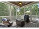 Relaxing screened porch with a ceiling fan, comfortable seating, and wooded views at 117 Synandra Ln, Holly Springs, NC 27540
