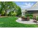 Green backyard featuring a patio with a fire pit, outdoor seating, dining table, and a grill at 125 Lord Ashley Rd, Raleigh, NC 27610