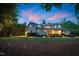 Backyard at dusk featuring a patio with a fire pit, outdoor seating, dining table, and landscaping at 125 Lord Ashley Rd, Raleigh, NC 27610
