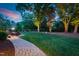 A beautiful backyard with a stone paver patio, manicured lawn, landscaping and mature trees at 125 Lord Ashley Rd, Raleigh, NC 27610