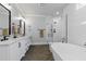 Bright bathroom featuring double sinks, a glass-enclosed shower, and a luxurious soaking tub at 125 Lord Ashley Rd, Raleigh, NC 27610