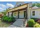 Inviting front porch with dark wood beams, stone steps and black iron handrail at 125 Lord Ashley Rd, Raleigh, NC 27610