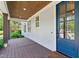 Covered front porch with wood decking, blue door, and a hanging swing at 125 Lord Ashley Rd, Raleigh, NC 27610