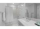 Bright bathroom features a shower-tub combo, white tile, and vanity with a large mirror at 1305 Queensferry Rd, Cary, NC 27511
