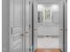 Bright bathroom featuring double vanity, white marble floors, and a view through shuttered windows at 1305 Queensferry Rd, Cary, NC 27511