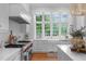Elegant kitchen featuring stainless steel appliances, a farmhouse sink, and marble countertops at 1305 Queensferry Rd, Cary, NC 27511