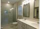 Bathroom with glass shower, double sink vanity with white cabinets and chrome fixtures at 1311 Arena Ln, Fuquay Varina, NC 27526