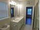 Bathroom with double sinks, framed mirrors, and a view into the walk-in closet and bedroom at 1311 Arena Ln, Fuquay Varina, NC 27526