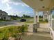 Relaxing covered porch with stone pillars, landscaped garden, and neighborhood views at 1311 Arena Ln, Fuquay Varina, NC 27526