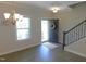 Bright foyer featuring hardwood floors, a staircase, chandelier, and an open door with wreath at 1311 Arena Ln, Fuquay Varina, NC 27526