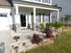 Front entrance with covered porch featuring stone pillars and landscaped garden at 1311 Arena Ln, Fuquay Varina, NC 27526