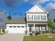 Traditional two-story home featuring a two car garage, manicured lawn and stone accents at 1311 Arena Ln, Fuquay Varina, NC 27526